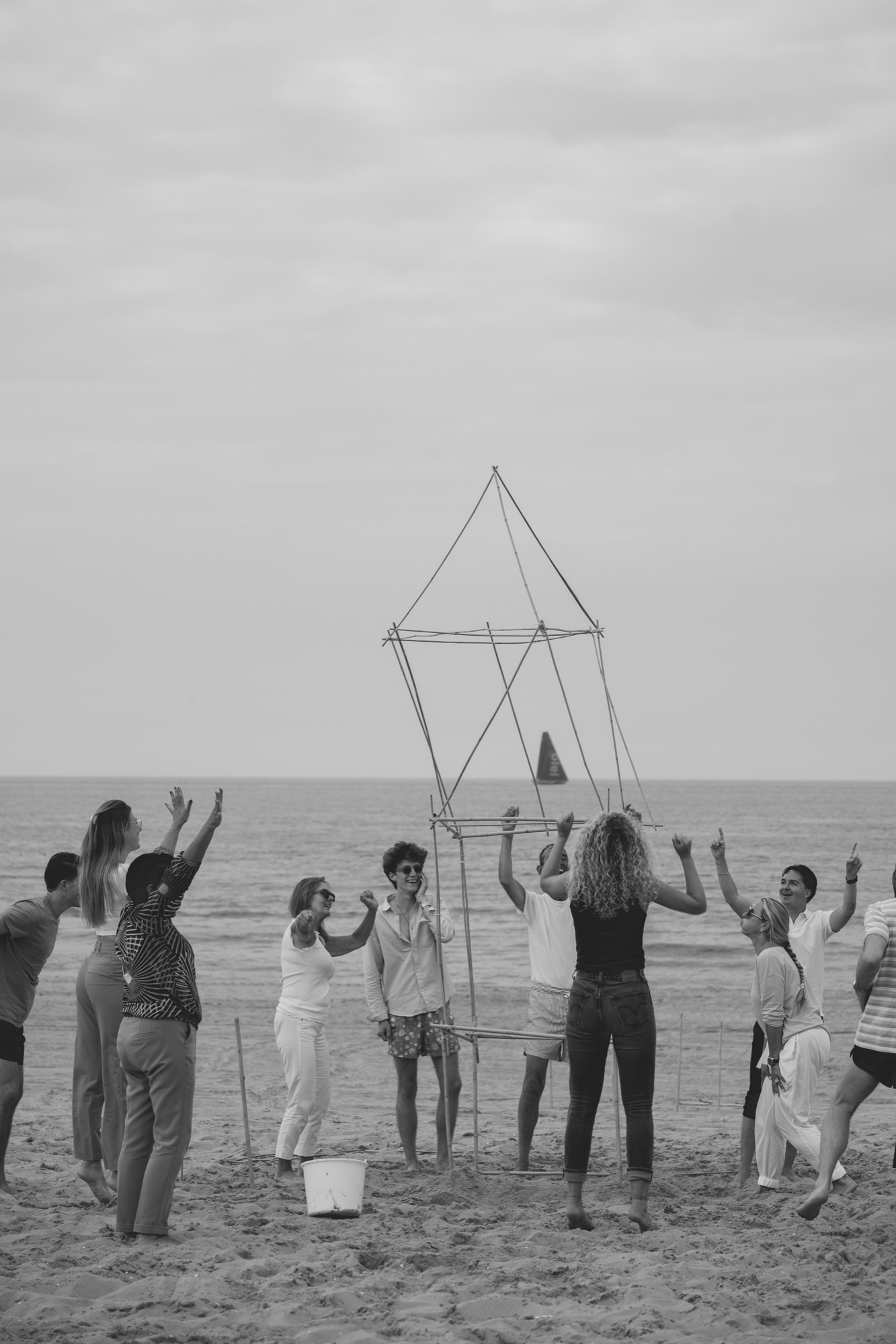 Team building a structure together on the beach