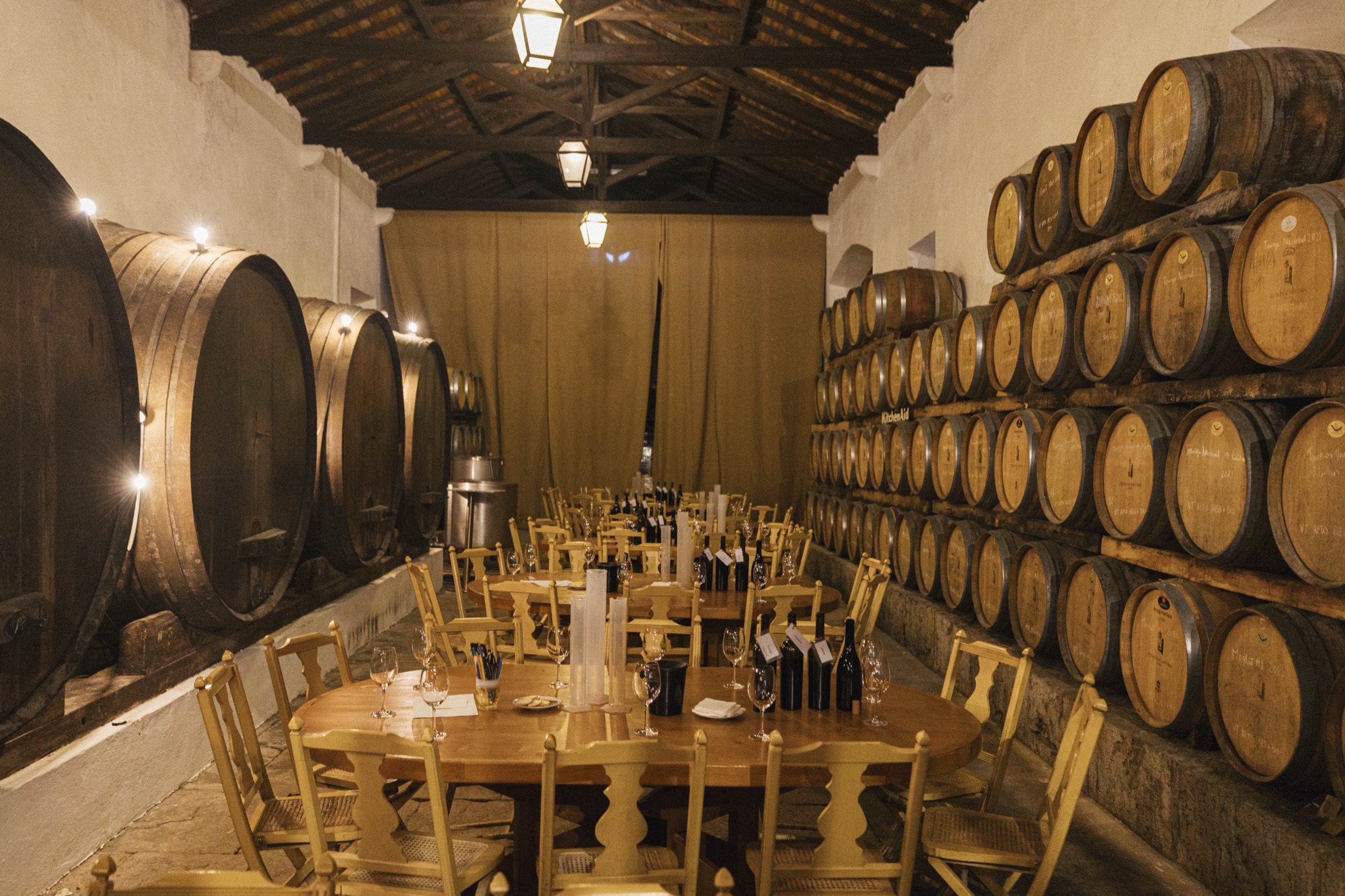 Long tables between the wine barrels for a wine blending workshop